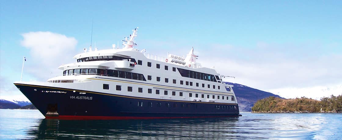 Un luxueux navire croisière, le VIA AUSTRALIS, navigue dans des eaux calmes, témoignant d'une expédition TMR Voyages.