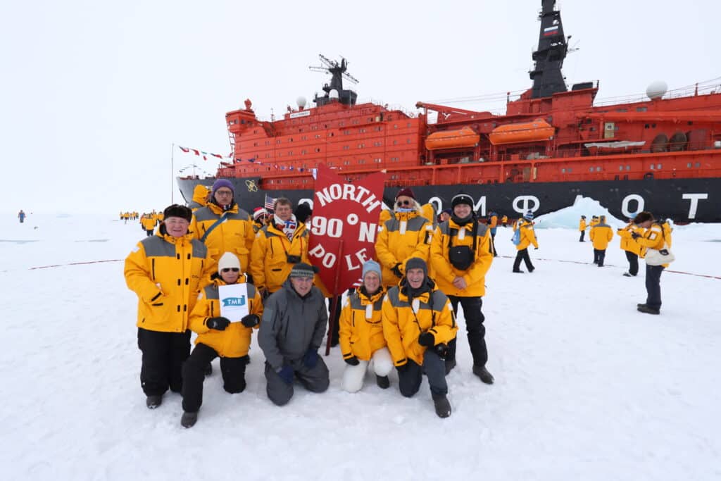 Groupe en expédition au Pôle Nord, vivant une aventure authentique avec TMR Voyages, entouré de paysages arctiques.