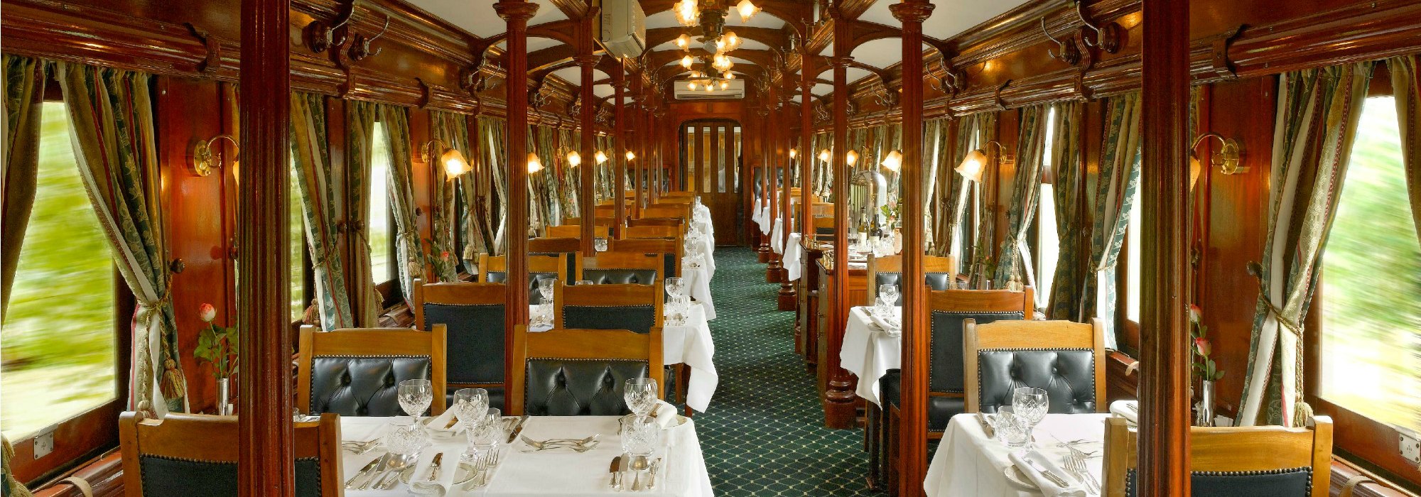 Intérieur élégant d'un train de luxe, avec tables dressées, parfait pour un voyage d'exception avec TMR Voyages.