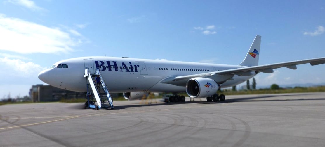 Un avion de BHAir stationné sur un tarmac, prêt pour un voyage de luxe avec TMR Voyages sous un ciel bleu clair.