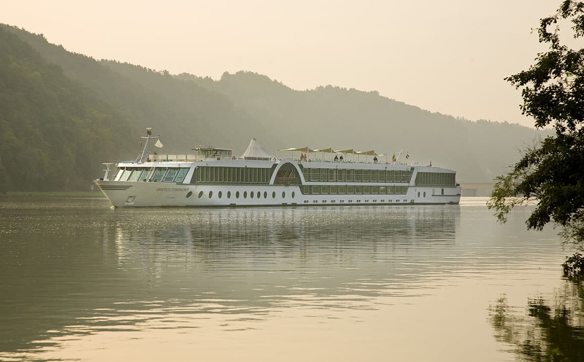 Une croisière de luxe sur un majestueux bateau naviguant paisiblement dans un paysage tranquille. TMR Voyages vous invite à explorer.