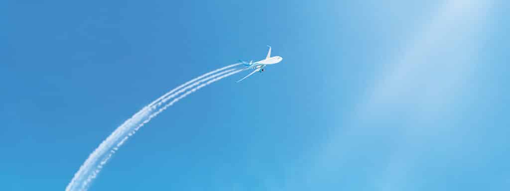 Avion survolant des destinations emblématiques, symbole des voyages sur mesure de TMR Voyages.