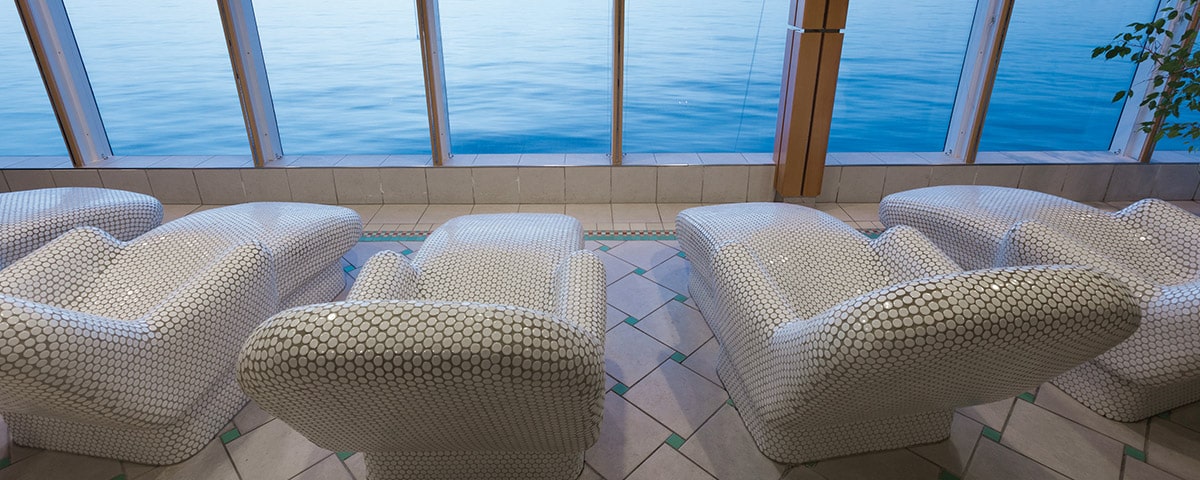 Chaises élégantes face à une vue apaisante sur l’eau, idéales pour un voyage de luxe avec TMR Voyages.