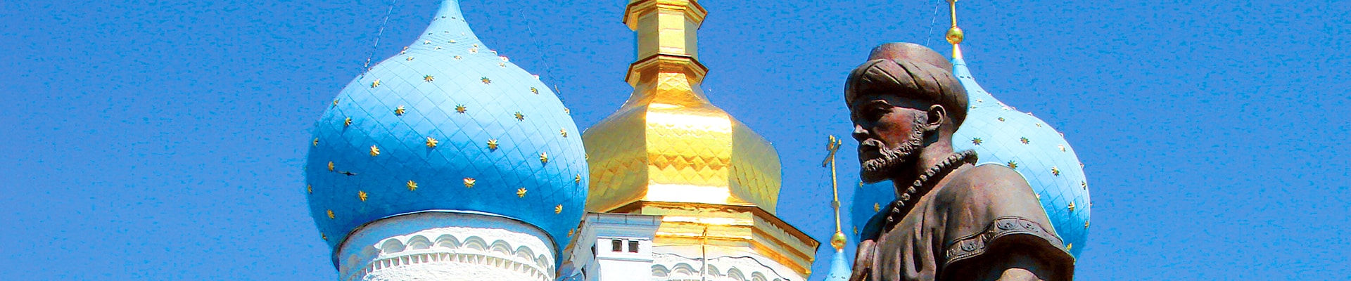Dôme bleu et or de la cathédrale avec statue d'un personnage historique, symbole de découvertes culturelles en Russie.