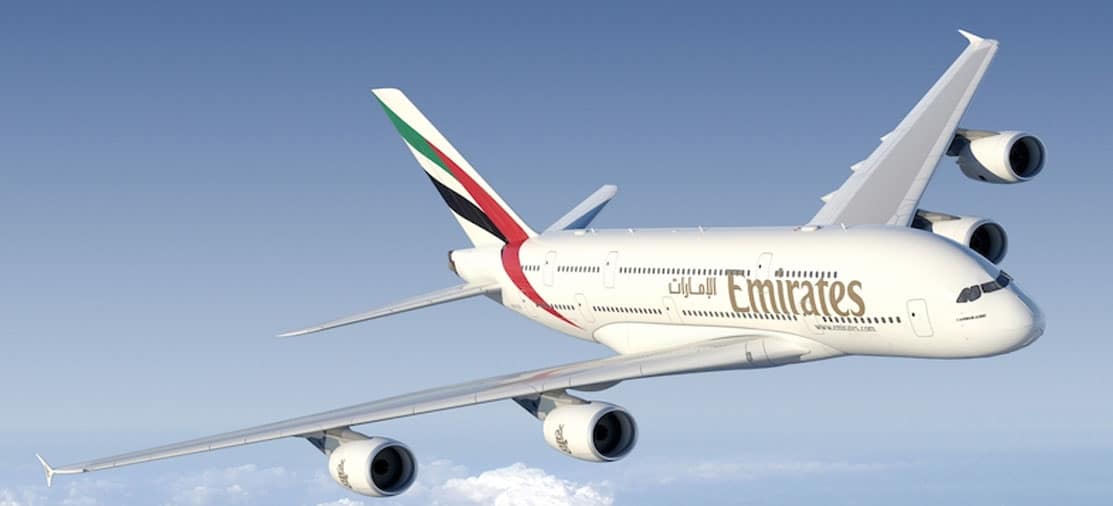 Un avion Emirates survole un ciel bleu, symbole d'un voyage d’exception proposé par TMR Voyages.