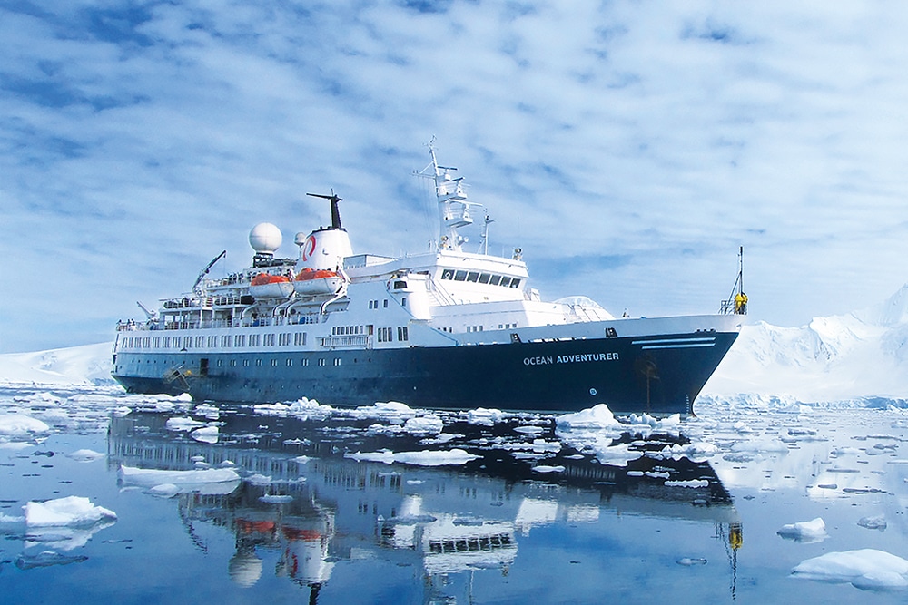 Un majestueux navire de croisière, « Ocean Adventurer », navigue au milieu des glaces, une aventure unique avec TMR Voyages.