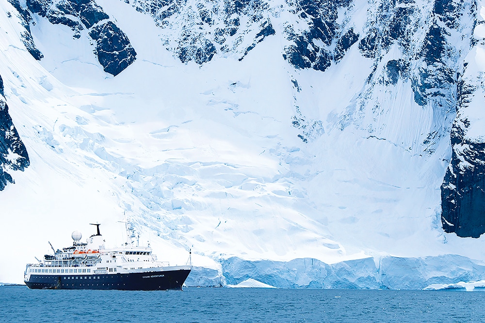 Un navire de croisière de luxe navigue près d'impressionnantes glaciers, une destination exclusive de TMR Voyages.