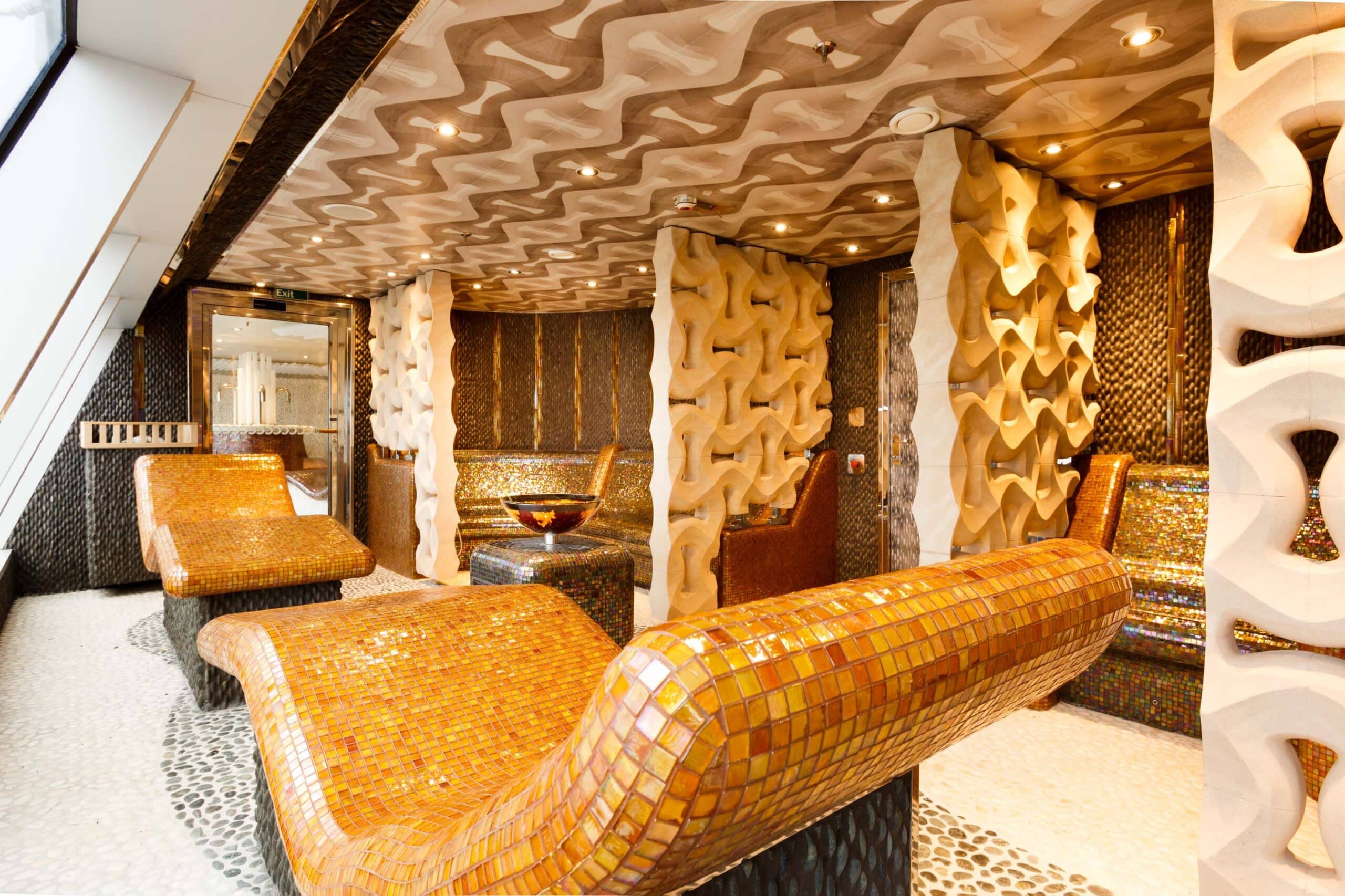 Un espace luxueux aux textures dorées et mur en mosaïque, idéal pour un voyage d'exception avec TMR Voyages.
