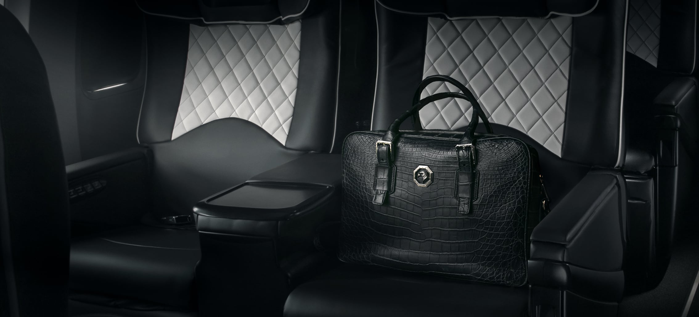 Des sièges en cuir noir accueillent un sac élégant, symbole de voyage de luxe, avec TMR Voyages.