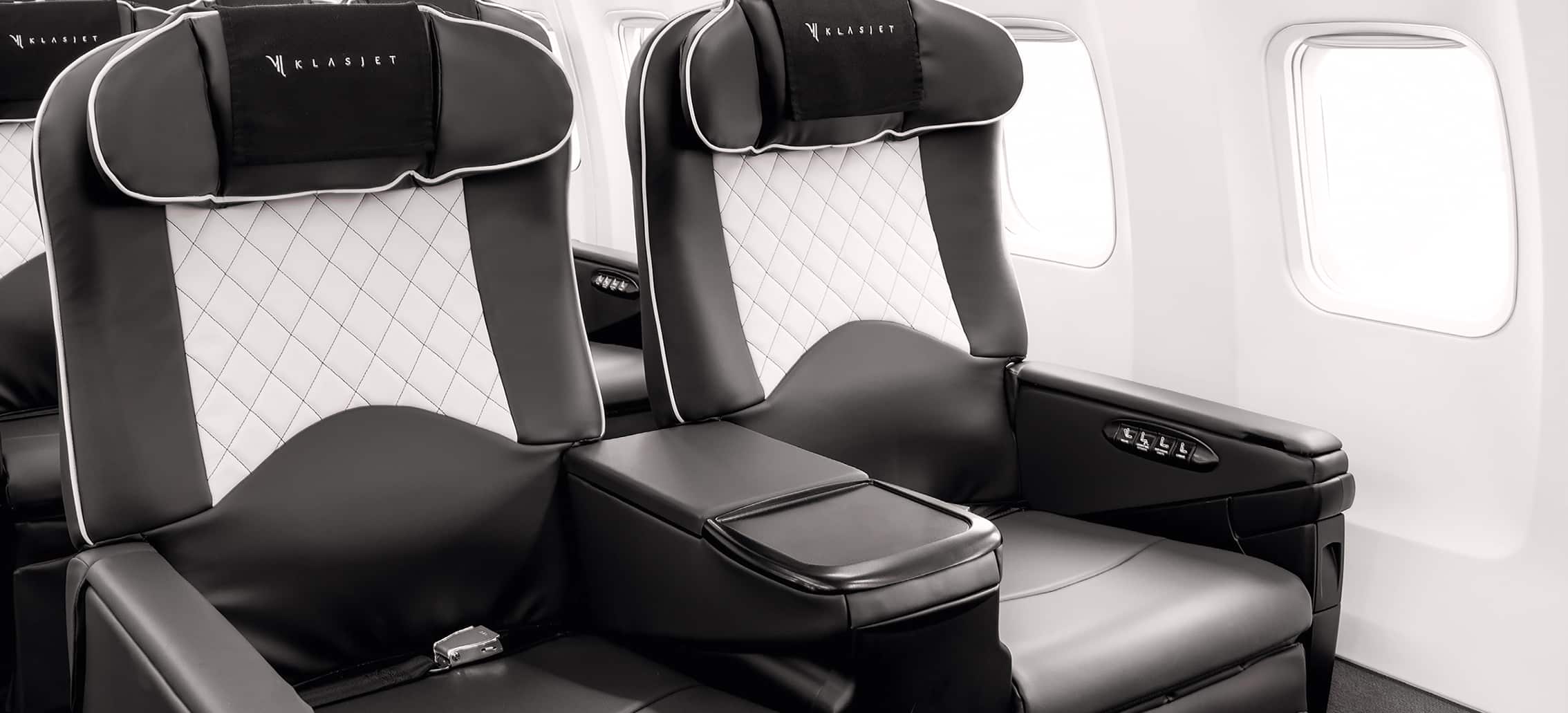 Sièges en cuir noir et blanc dans un avion, symbole d'un voyage de luxe avec TMR Voyages.