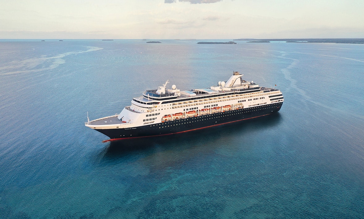 Un croiseur majestueux au large des eaux cristallines, parfait pour un voyage de luxe avec TMR Voyages.