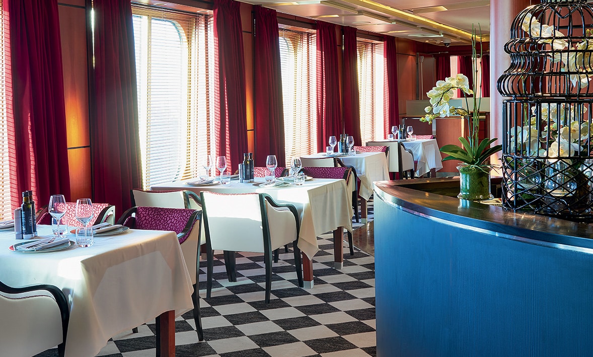 Un restaurant élégant avec des tables dressées, idéal pour un voyage d’exception avec TMR Voyages. Ambiance raffinée et lumineuse.