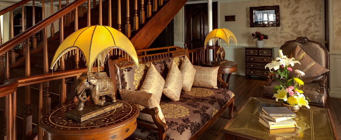 Salon raffiné avec éclairage élégant et décor en bois, idéal pour un voyage de luxe avec TMR Voyages.