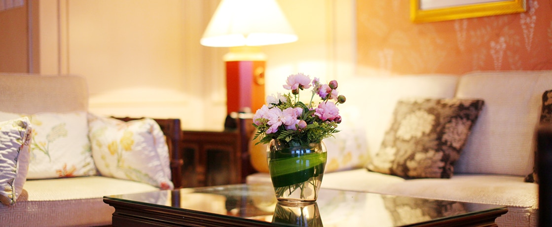 Un salon élégant avec des coussins décoratifs et un vase fleuri, idéal pour un voyage d’exception avec TMR Voyages.