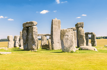 Stonehenge émerge majestueusement sous un ciel bleu, emblème d'un voyage d'exception avec TMR Voyages.